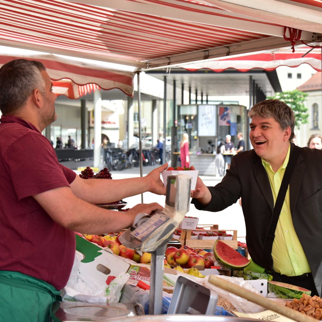 stefan-schmidt-mdb-homepage-wahlkreis Stefan Schmidt - Mitglied des Deutschen Bundestages kauf an einem Marktstand in Regensburg Gemüse ein.